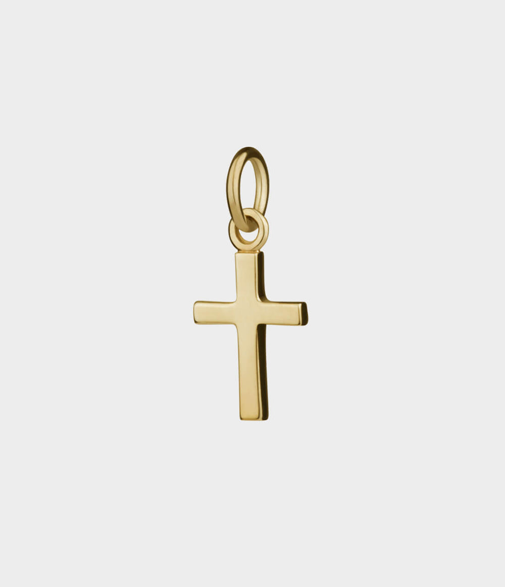 a side view of a yellow gold cross charm