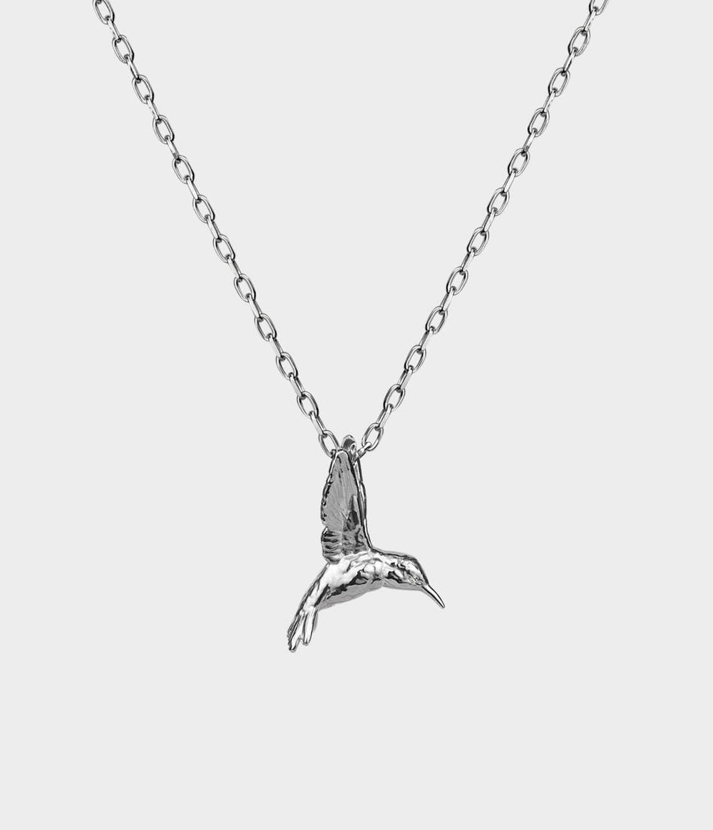 side view of a silver hummingbird necklace with diamonds