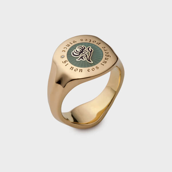 A yellow gold signet ring with a family crest at the top.