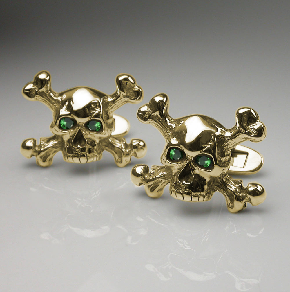 A close up of some yellow gold and tsavorite cufflinks