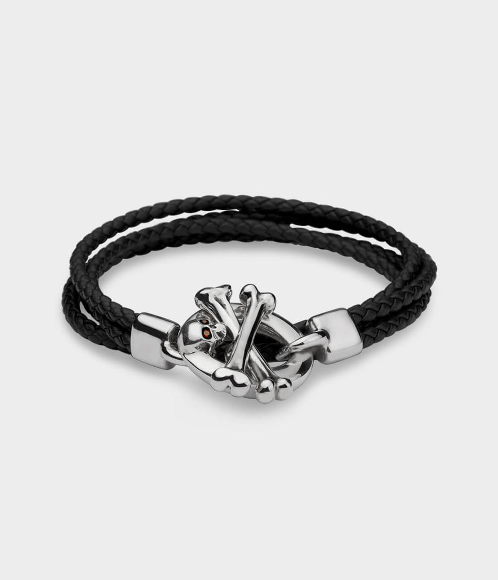 A brown leather double strand bracelet with a detailed silver skull and crossbone T bar catch with ruby eyes