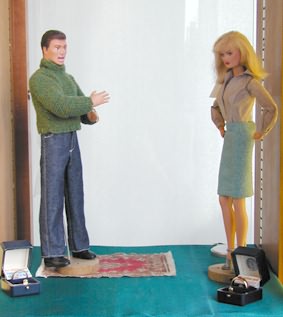 Destinee and Dirk dolls facing each other in a room set, with two open ring boxes on the floor