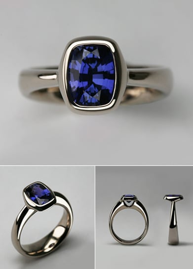 White gold ring with a bezel-set cushion-cut blue sapphire, shown from above, at an angle and in profile