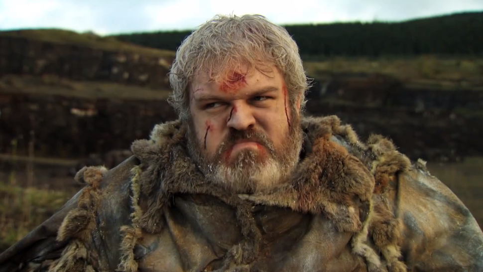 Kristian Nairn as Hodor in Game of Thrones, bearded with a cut brow and a fur cloak on a moorland hillside