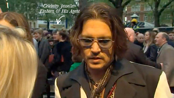 Johnny Depp in tinted glasses and layered necklaces talking to press at the Dark Shadows London premiere