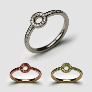 Three open circle pavé rings: white gold with diamonds, rose gold with red stones and gold with green stones