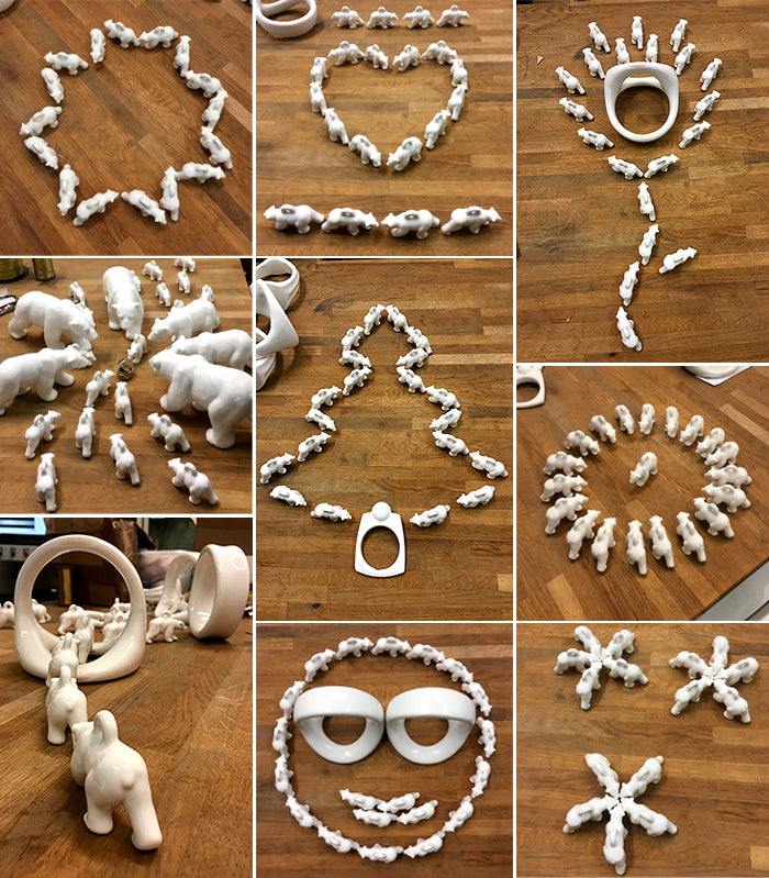 White polar bear tree decorations arranged into a heart, a Christmas tree, a snowflake and a face on a wooden table