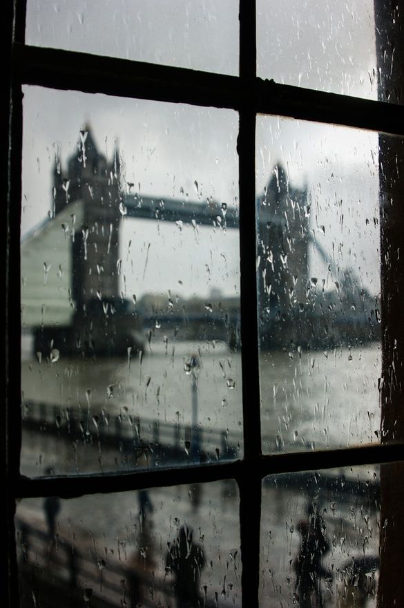 Rain-streaked window with a view across the Thames to Tower Bridge on a grey London day
