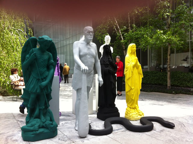 Colourful painted statues of an angel, a nude man, a Madonna and a black snake in the MoMA sculpture garden
