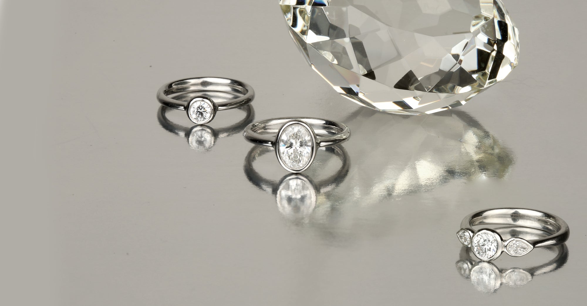Handcrafted engagement and wedding rings by Stephen Einhorn, balanced on stacked macarons, London luxury jewellery
