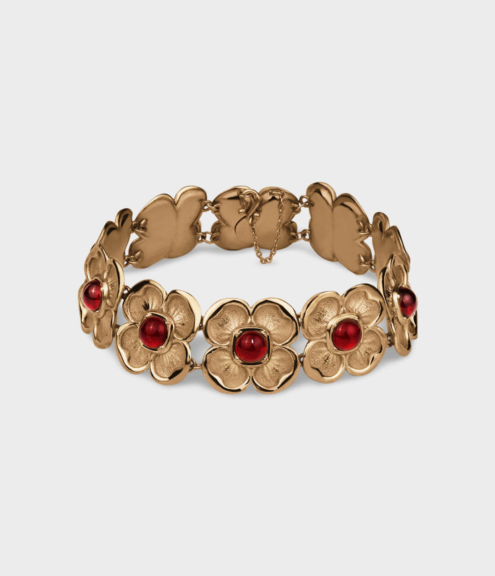 Yellow gold bracelet with interlinking flowers, each inset with a red ruby