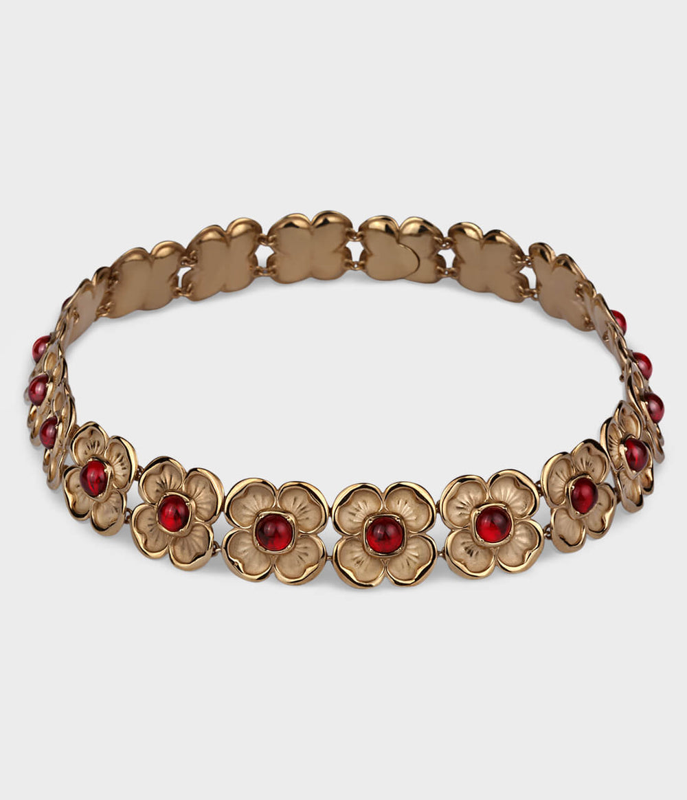 A large ornate choker featuring beautiful interlocking yellow-gold flowers that house a red ruby