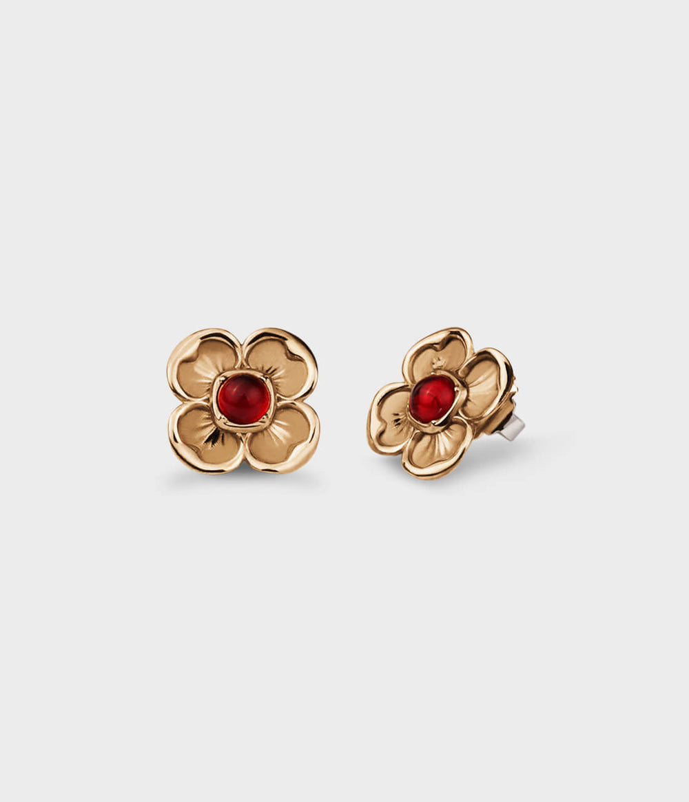 Yellow-gold flower earrings with four-petals, each one framing a red ruby