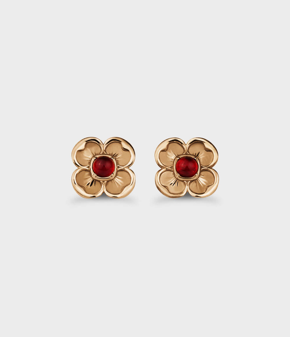 Yellow-gold flower earrings with four-petals, each one framing a red ruby