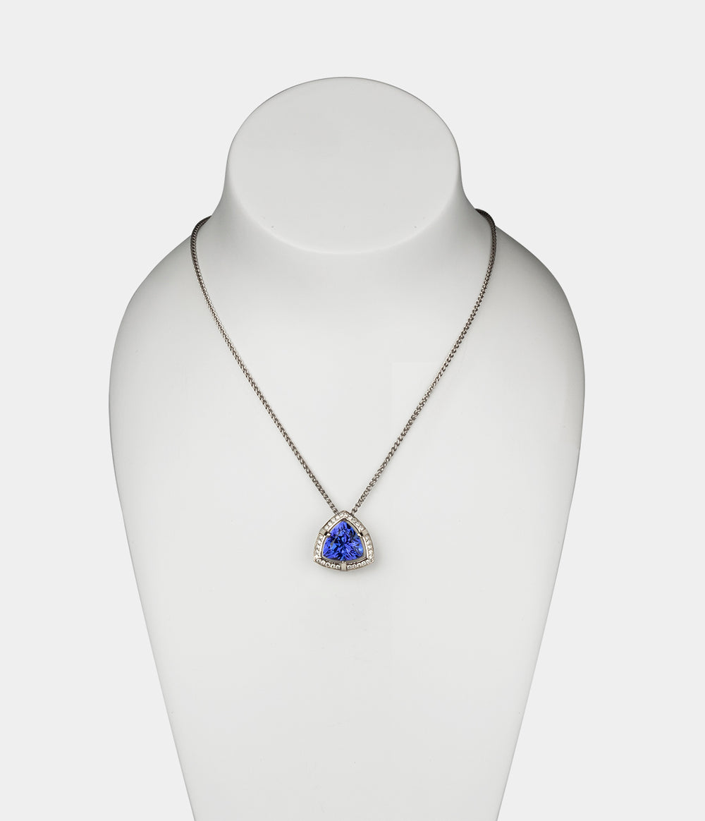 Tsarina Diamond Halo Necklace displayed on a model bust with a Trillion shaped Tanzanite central stone with a surrounding halo of diamonds