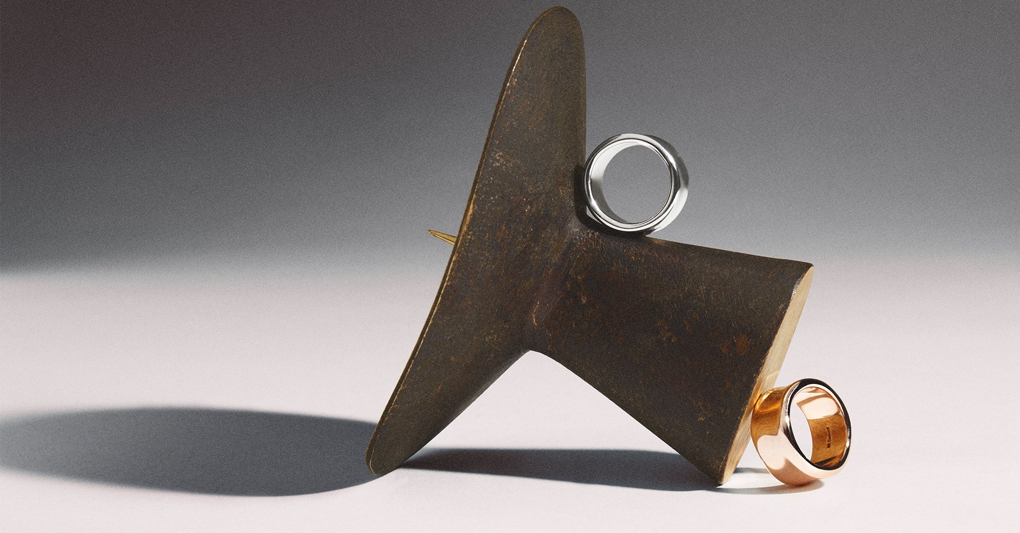 Smooth gold Liquid collection ring by Stephen Einhorn resting on a honey dipper, handcrafted luxury jewellery London