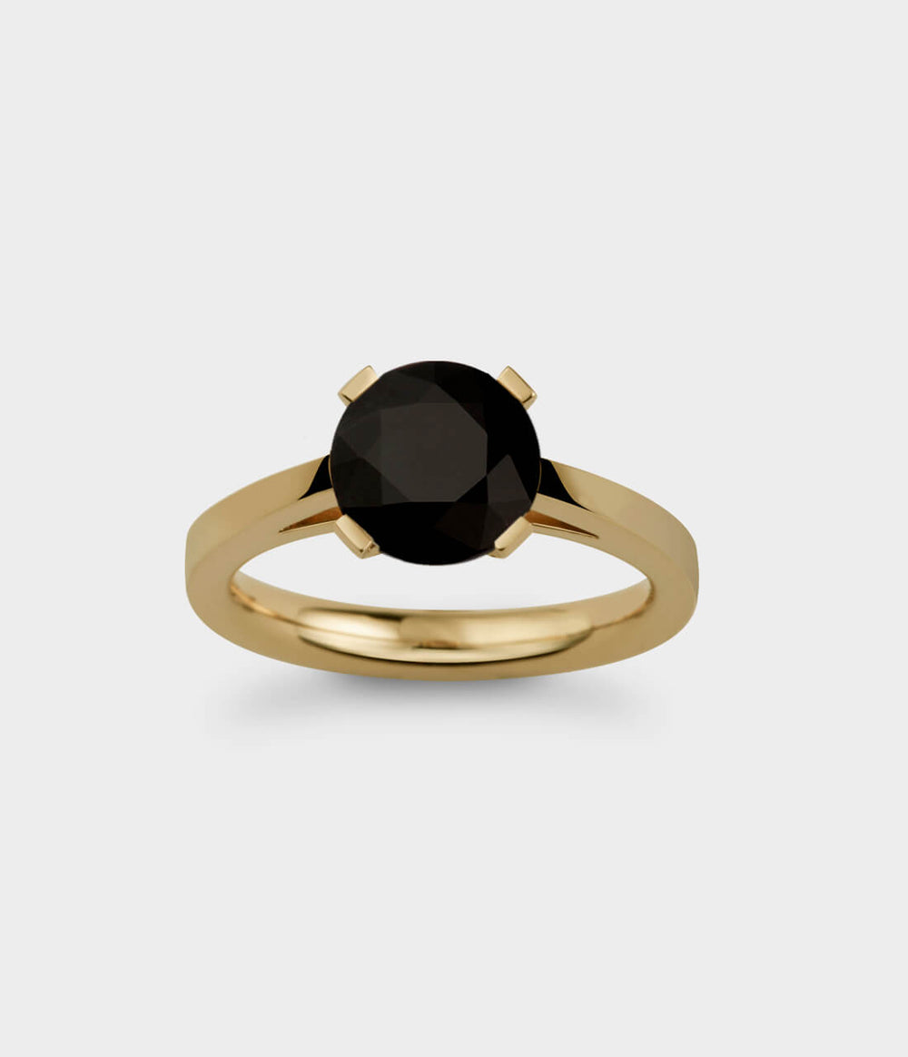 front view of a 2 carat rdiant light ring in yellow gold with a black sapphire.