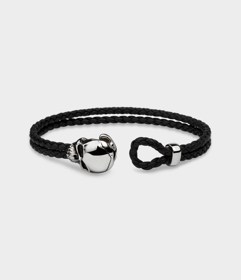 A black skull leather noose bracelet shown in close up, and shown open.
