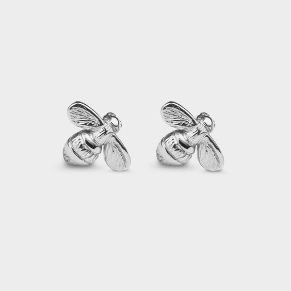 front view of two small bee stud earrings in silver.