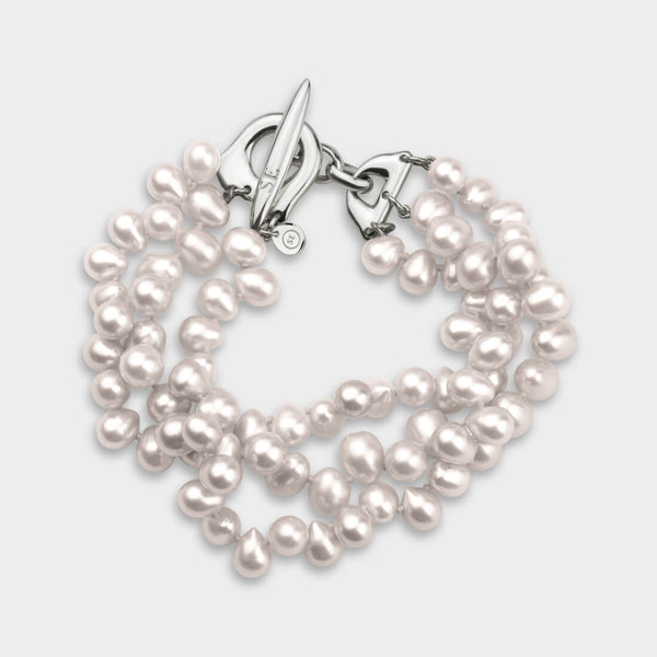 close up of a three strand pearl bracelet in white with silver endings.