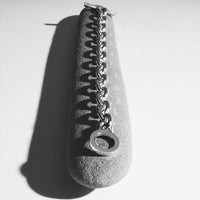 A black and white photo of the Knife Edge silver bracelet is shown on a long stone.