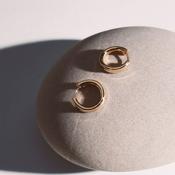 Hoop earrings from the liquid collection in rose gold on a grey round stone.