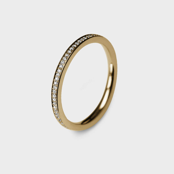 A slim yellow gold ring pavé set with tiny diamonds
