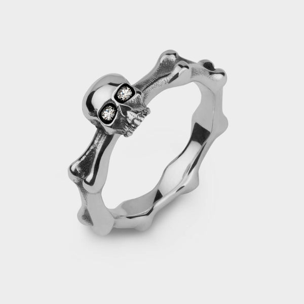 A mini skull and bones ring in sterling silver set with diamond eyes.