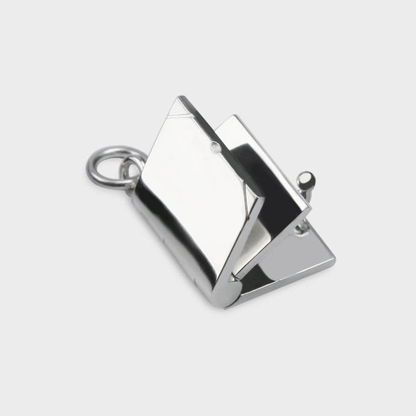 a close up of a silver Opening Book Charm