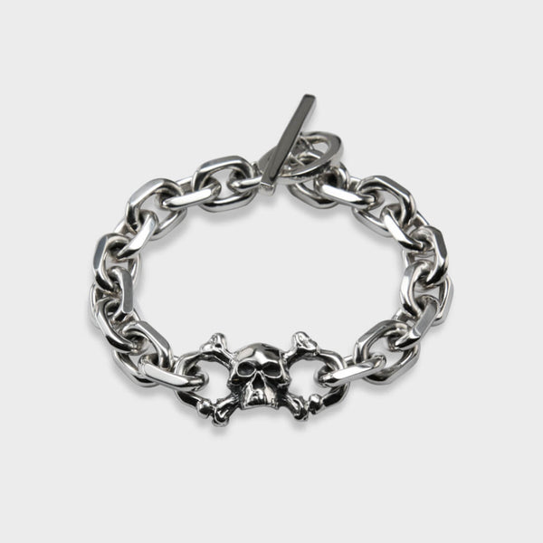 A plan view of a silver solid skull knife edge bracelet. 
