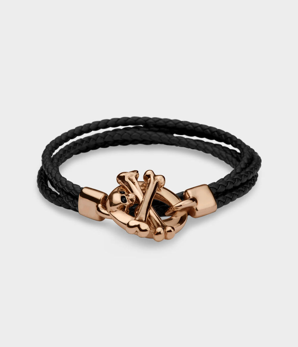 A black leather double strand  bracelet with a detailed rose gold skull and crossbone T bar catch with black sapphire eyes