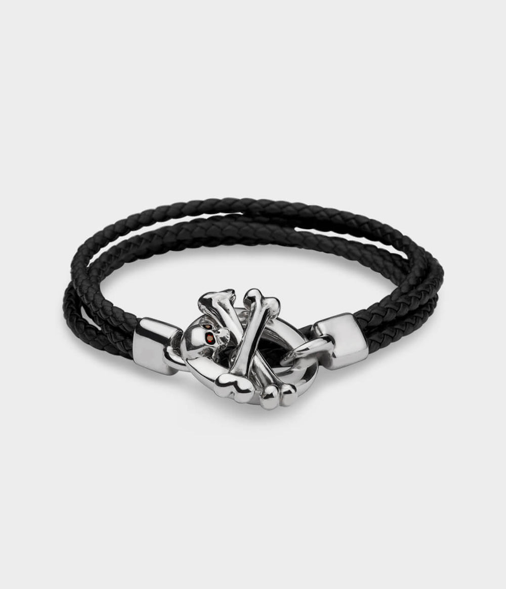 A brown leather double strand  bracelet with a detailed silver skull and crossbone T bar catch with ruby eyes