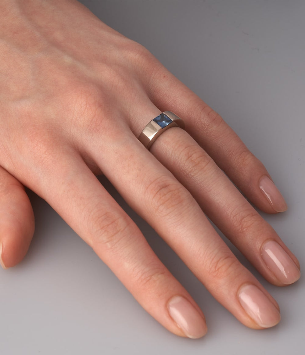 a womens hand wearing a white gold times square 4 ring with sapphire.